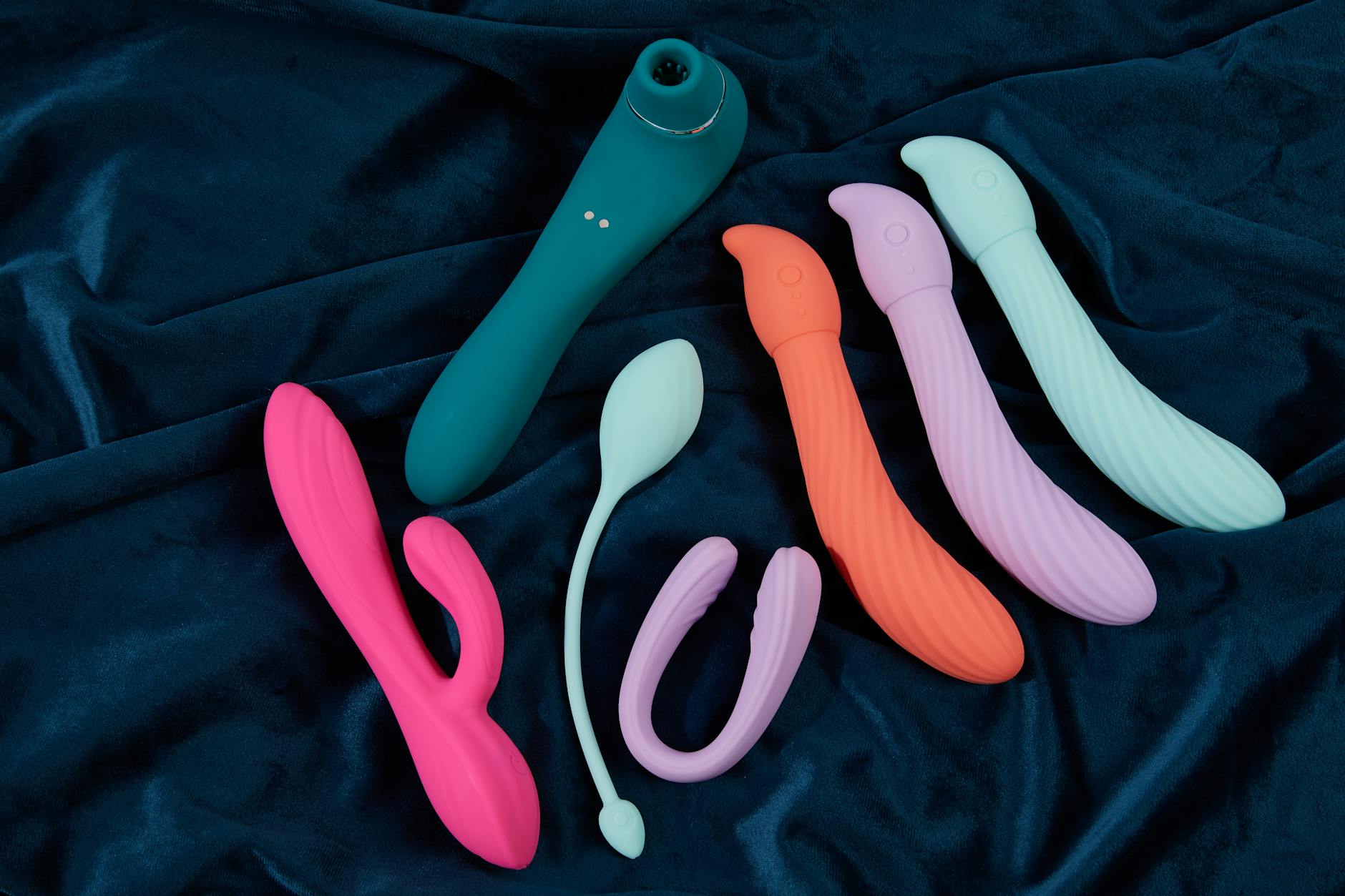 Hand hält einen modernen Vibrator gegen einen minimalistischen Hintergrund, der moderne Sinnlichkeit zeigt