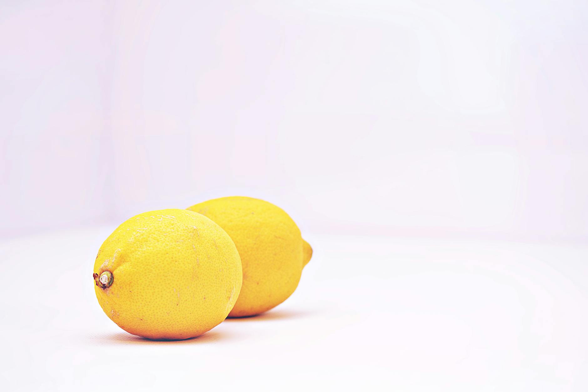 Bunter Zitronenvibrator umgeben von Blüten und Orangenscheiben auf gelbem Hintergrund