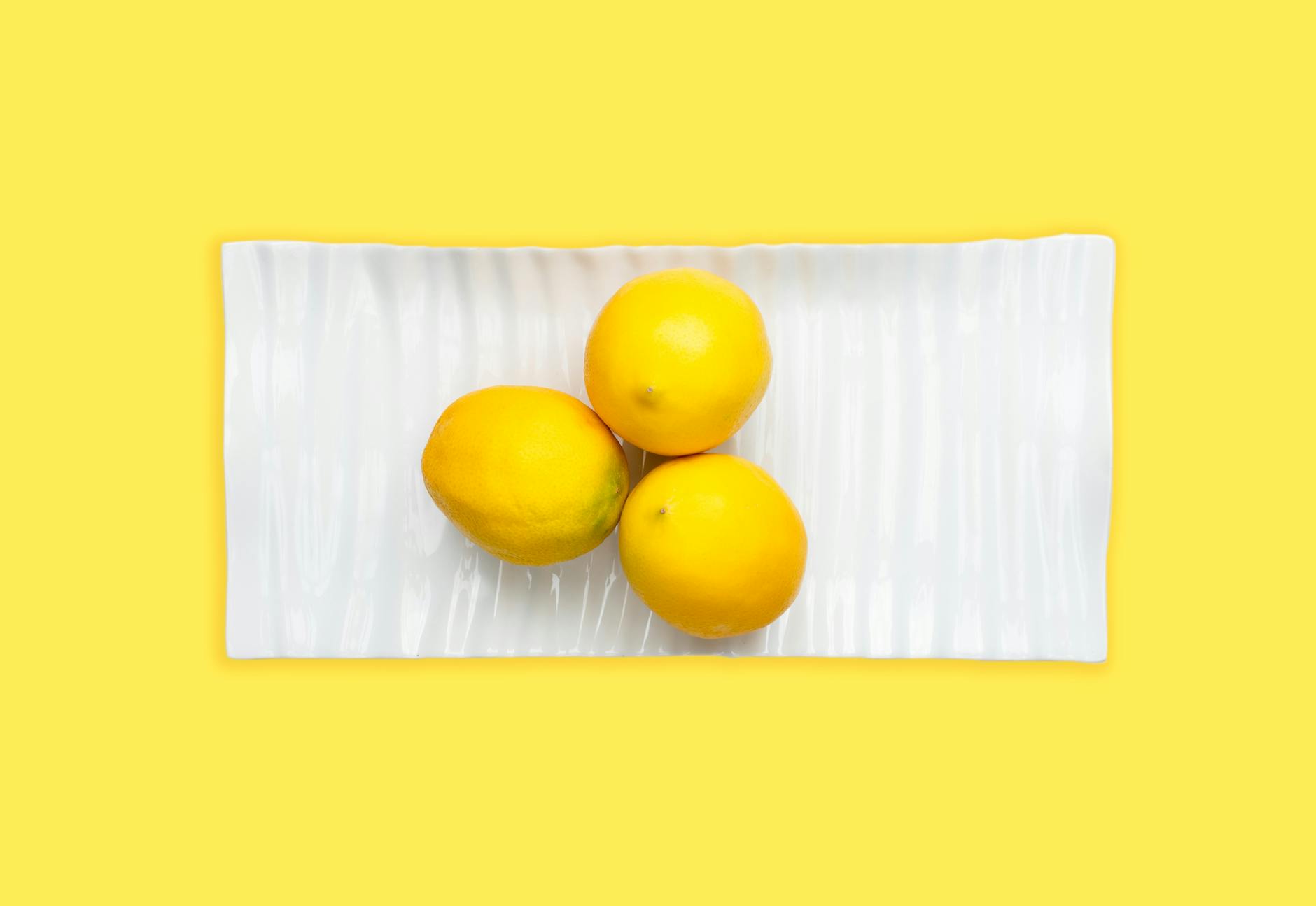 Ein gelber Silikonvibrator umgeben von geschälten Bananen auf gelbem Hintergrund, das Symbol für sanfte, intuitive Vergnügen