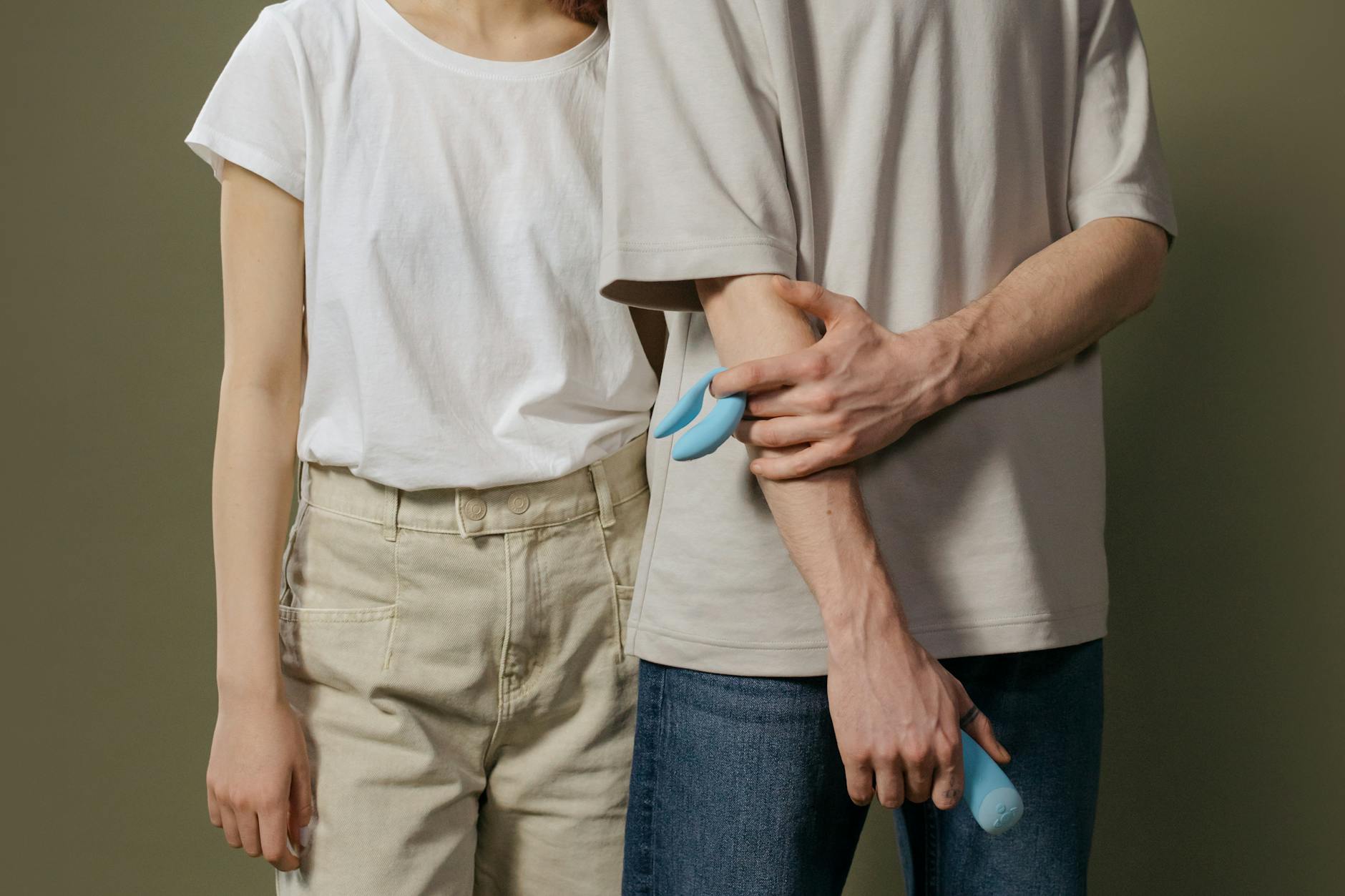 Ein junges Paar hält gemeinsam einen blauen Vibrator, das Symbol moderner Intimität und Vertrauen